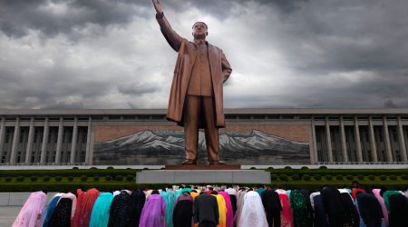 C0AGWE North Korean people in front of Kim Il Sung statue in Pyongyang North Korea